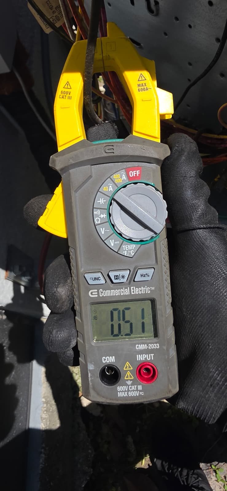 Multimeter displaying current near HVAC equipment in Odessa, FL 33556. Precision diagnostics.
