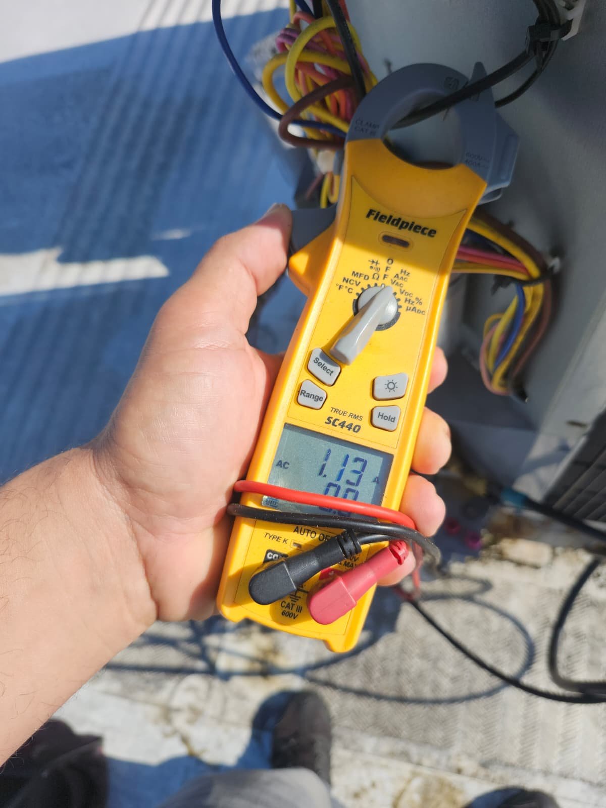 Technician holding multimeter showing current in Tampa, FL 33634.