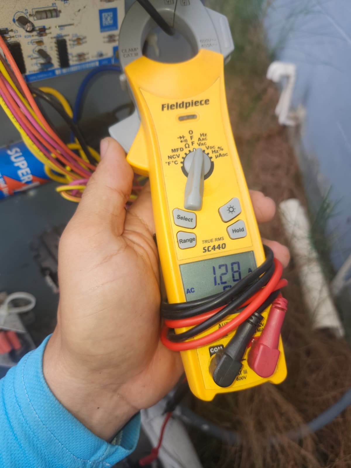 Hand holding a multimeter showing a reading during Visit #3 in Tampa, FL 33619.