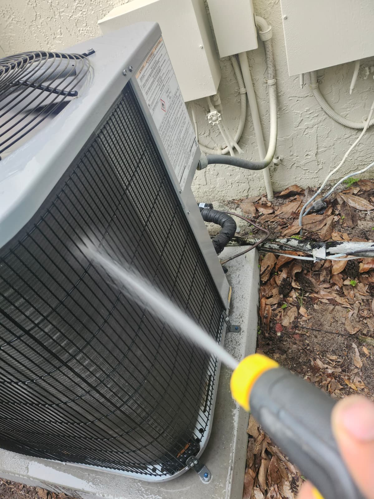 Outdoor AC Cleaning in Tarpon Springs, FL 34688 Outdoor AC unit being cleaned with water spray in Tarpon Springs, FL 34688. Efficient HVAC maintenance.