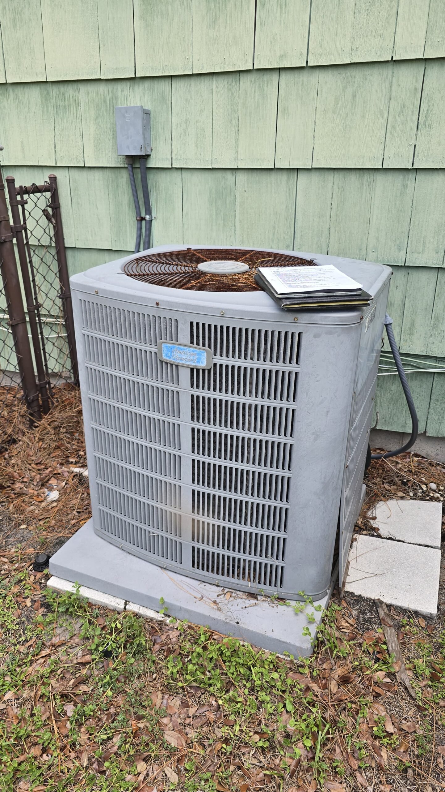 Outdoor AC Unit with Clipboard in Gulfport, FL 33707 Outdoor AC unit with clipboard on top beside house in Gulfport, FL 33707.