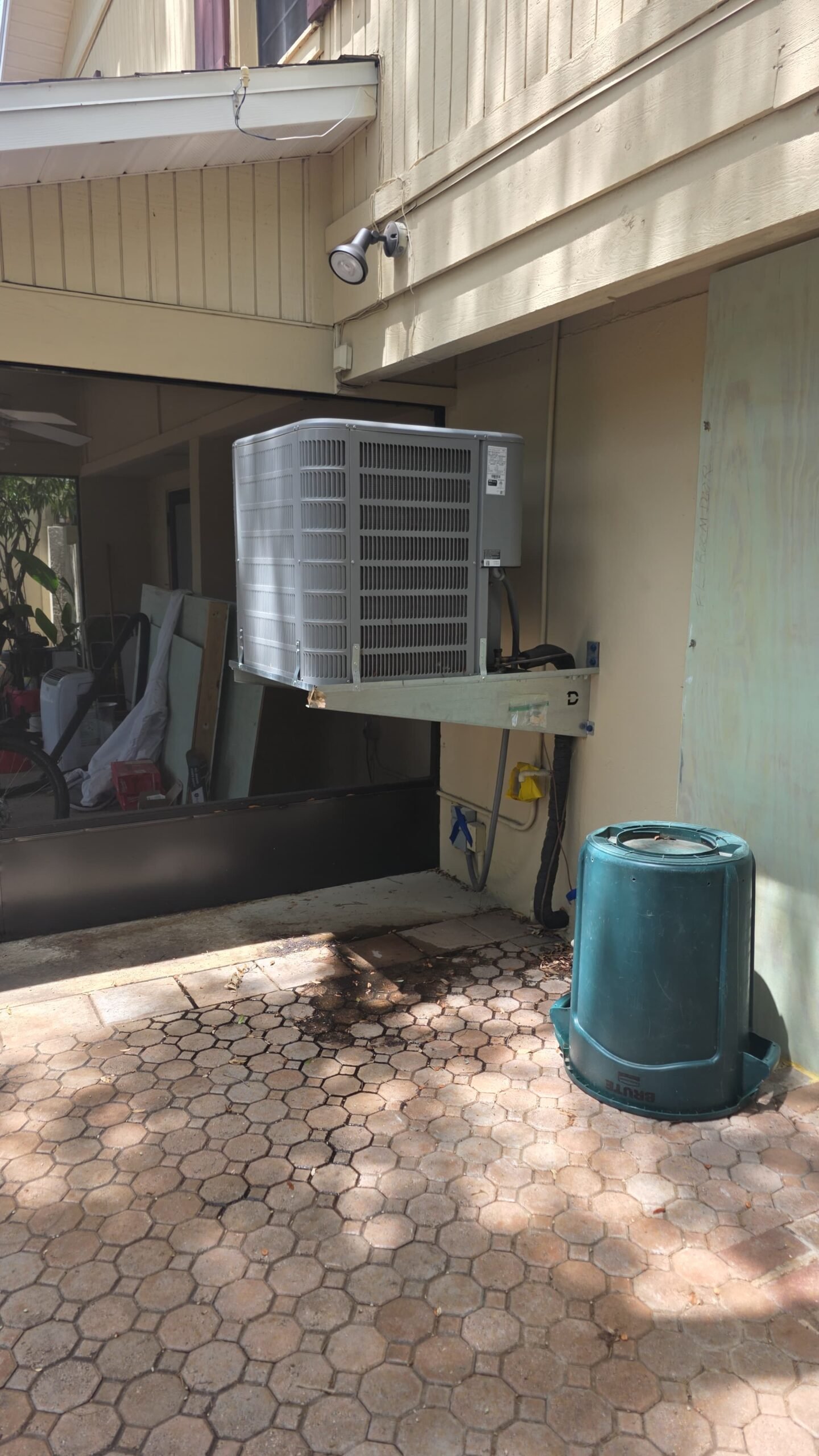 Outdoor AC unit mounted on wall beside house, Tampa, FL 33606.