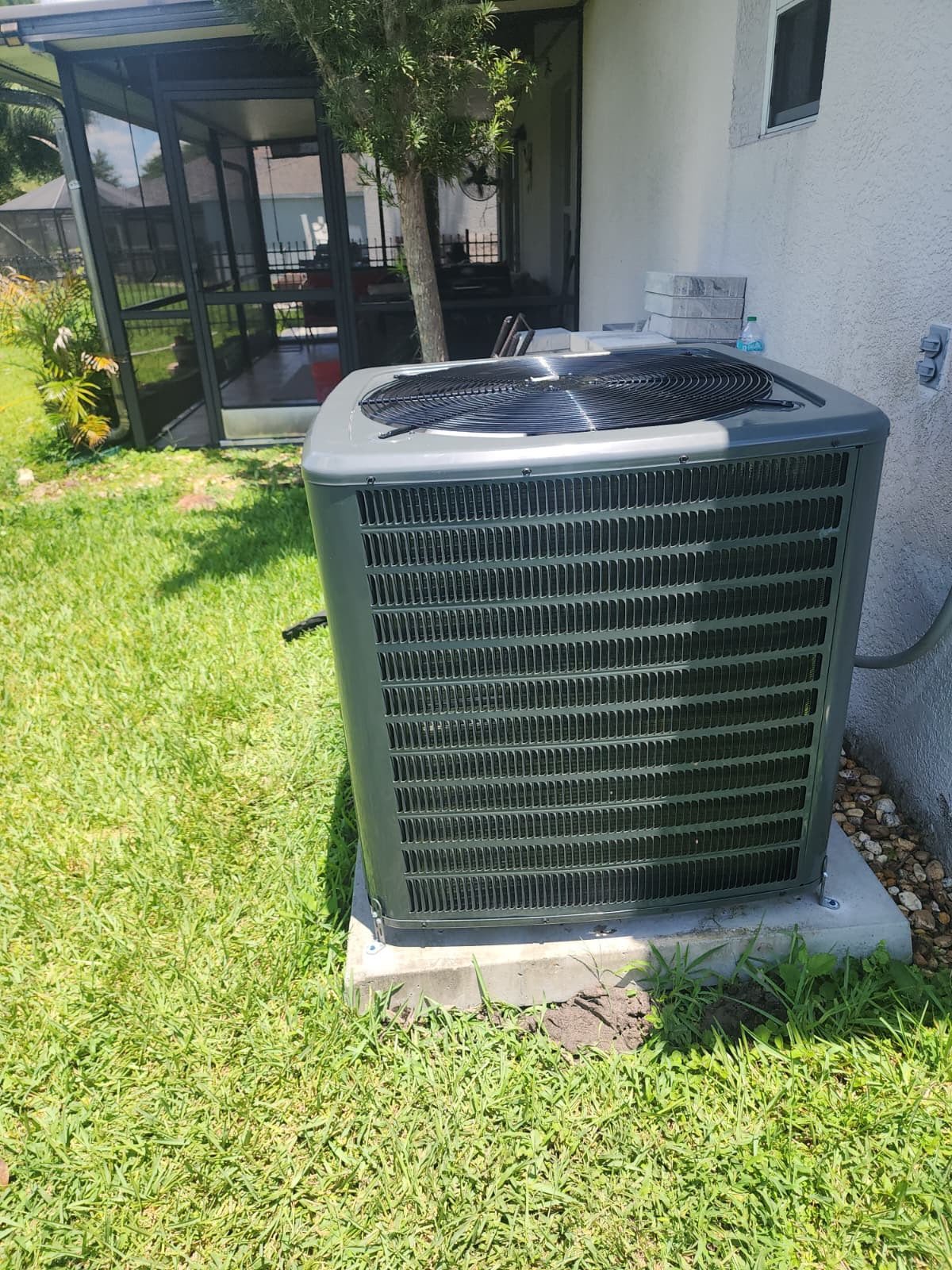 New outdoor AC unit on concrete pad in Wesley Chapel, FL 33545. Reliable cooling system.