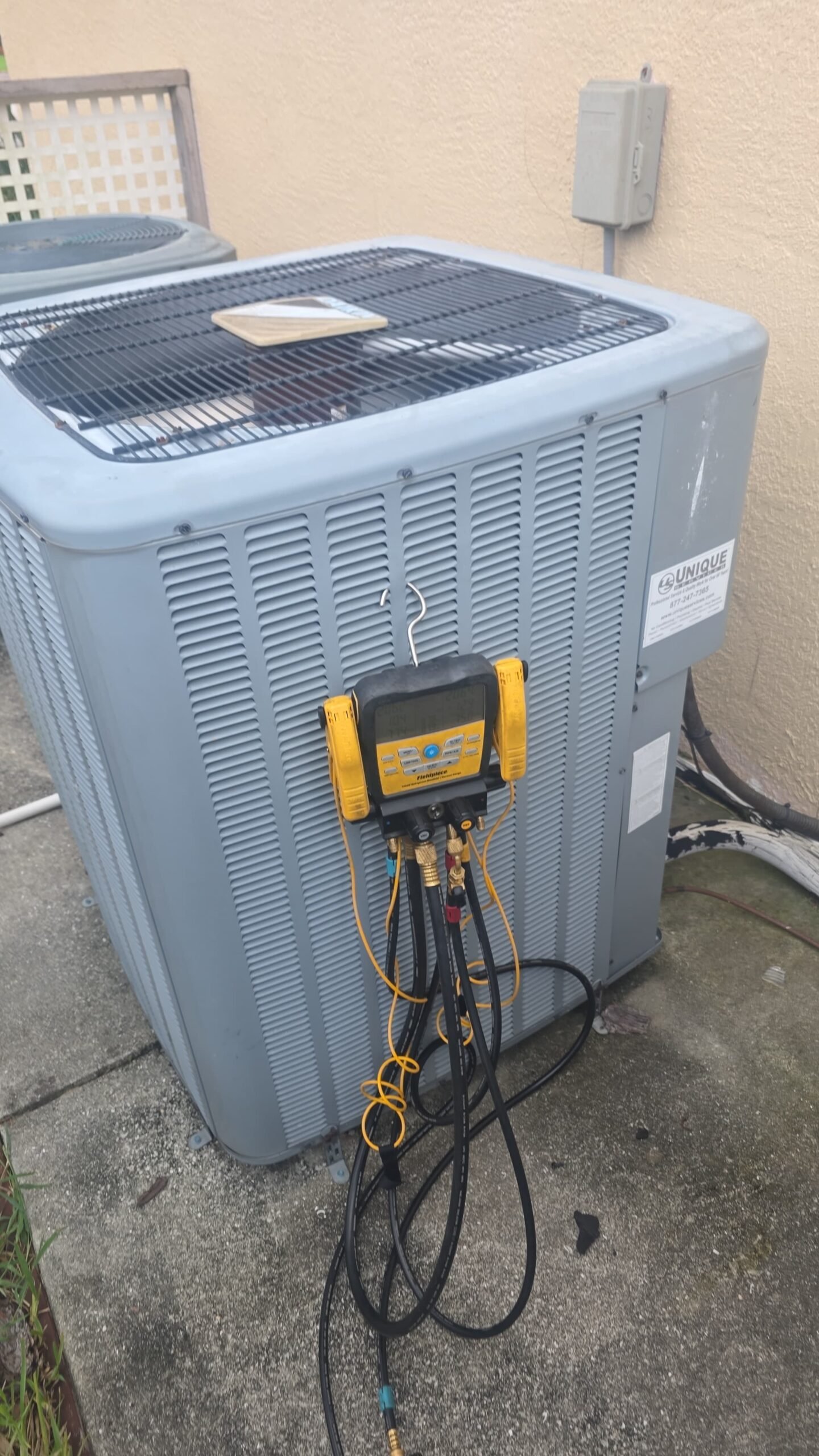 HVAC unit with manifold gauge outside home, part of Elite Therapy Plan in Bradenton, FL 34202.