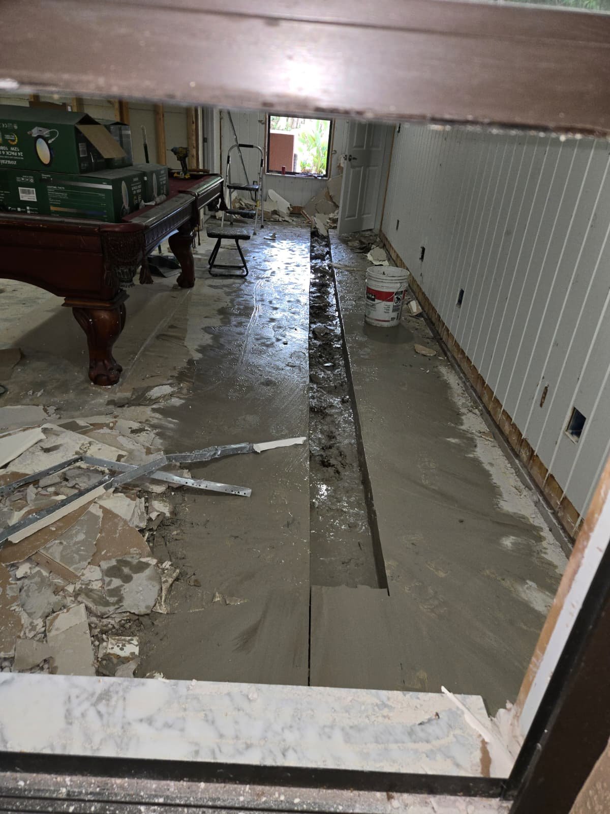 Room with flooring removed showing trench for plumbing work in Brandon, FL 33511.
