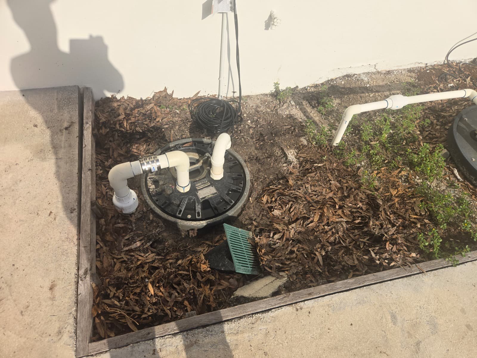 Pump and Piping in Landscaped Area - Tampa, FL 33634 Submersible sewage pump with piping and cover in Tampa, FL 33634.