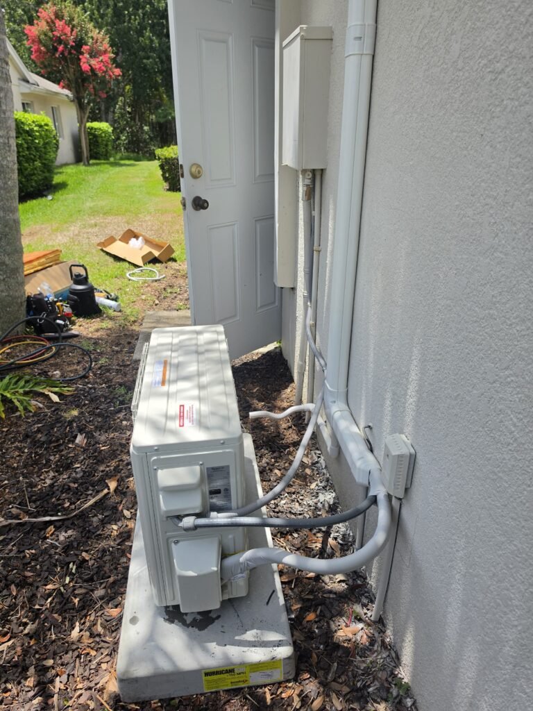 A mini-split outdoor unit installed along a side yard in Lutz, FL 33558.