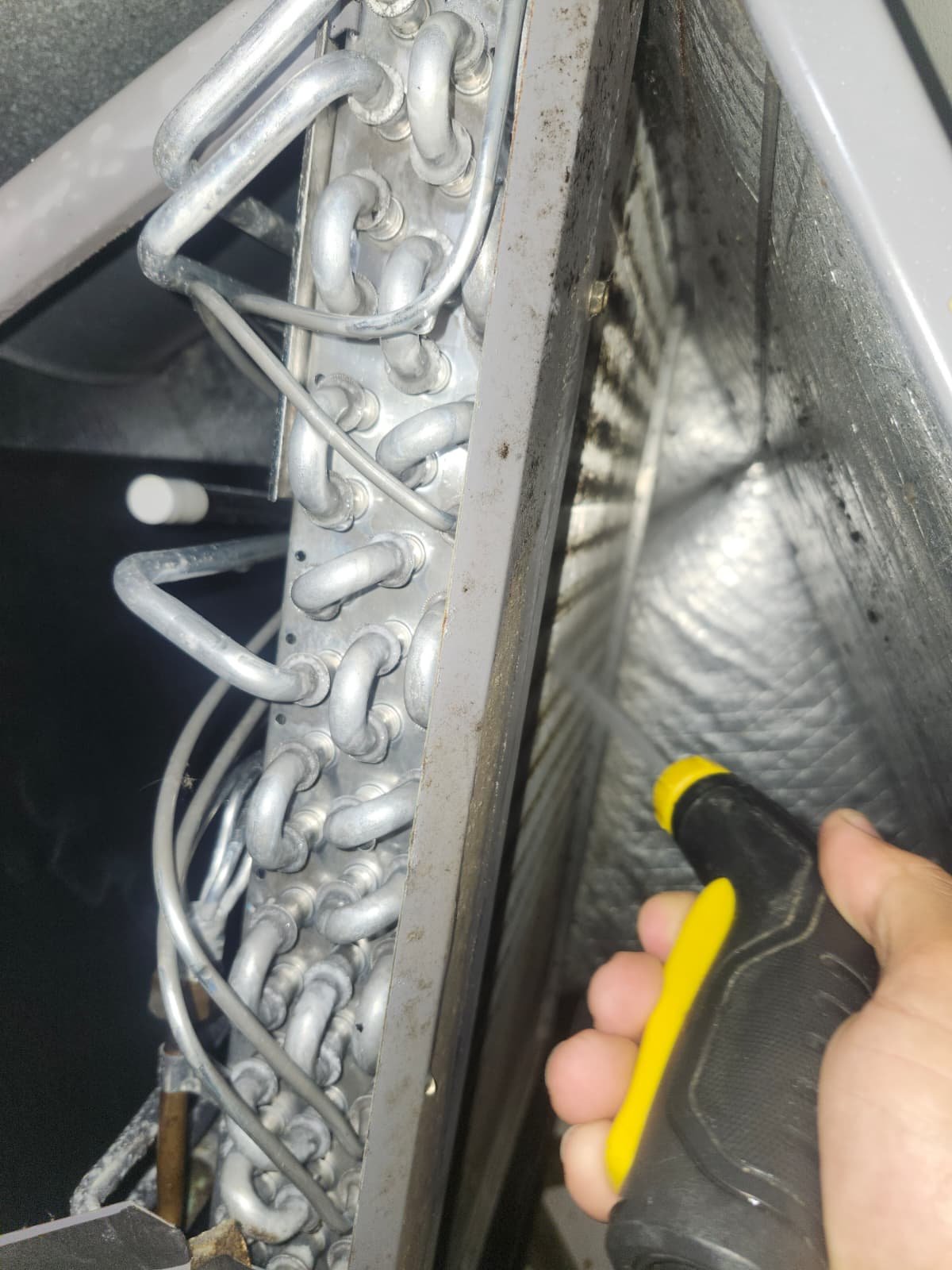 Spraying HVAC coils with a nozzle during Visit #3 in Tampa, FL 33619.