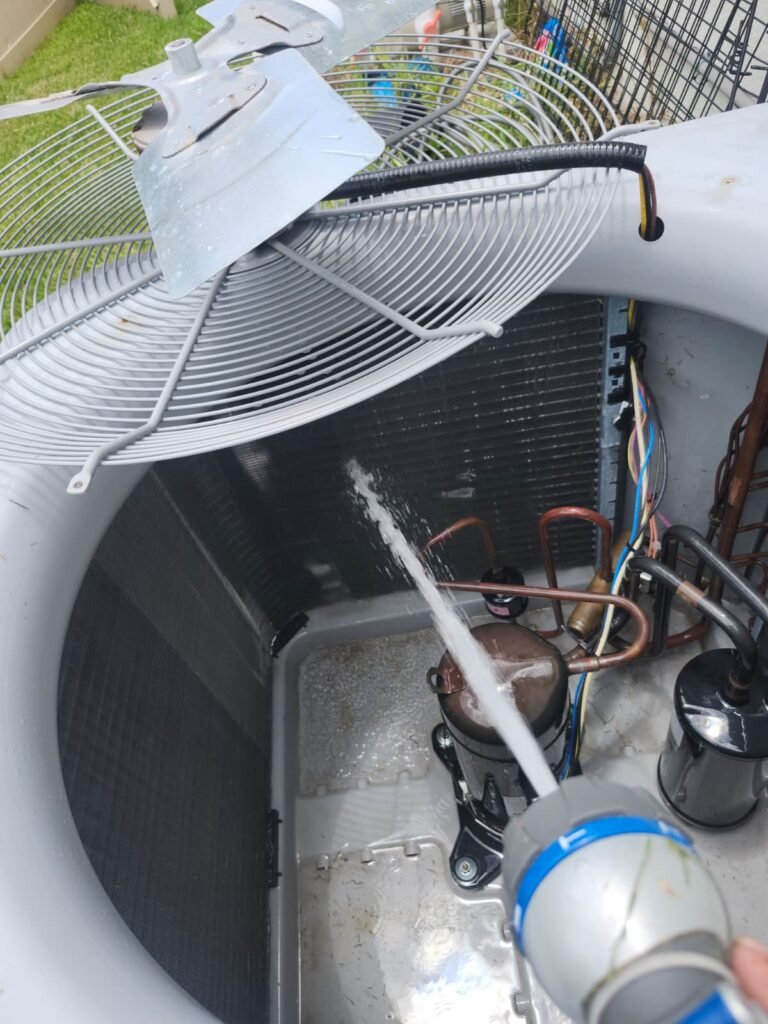 Spraying HVAC Unit in Land O' Lakes, FL 34637 Technician spraying water inside HVAC unit in Land O' Lakes, FL 34637