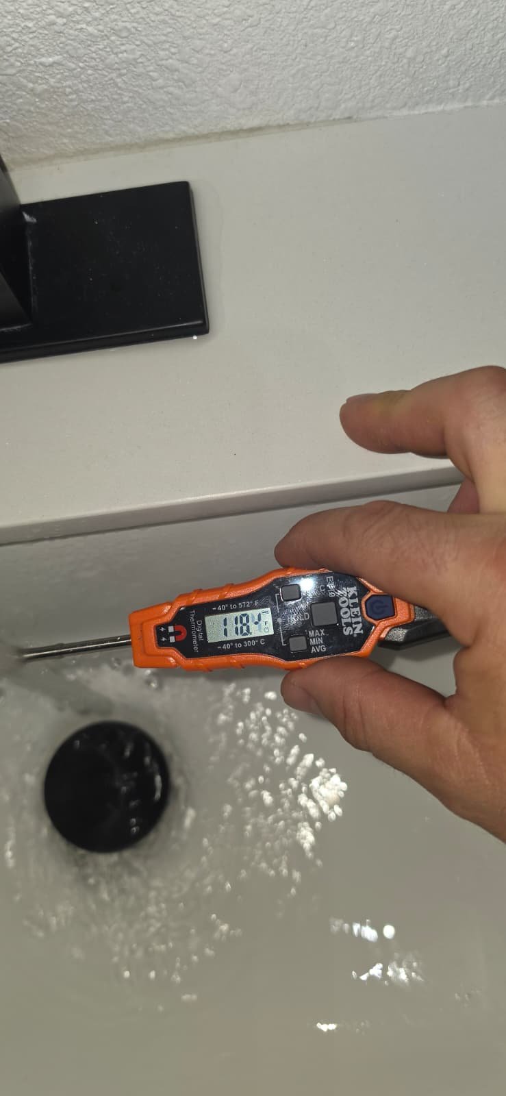 Temperature Check - Tampa, FL 33624 Hand with thermometer measuring water temperature in Tampa, FL 33624 sink.
