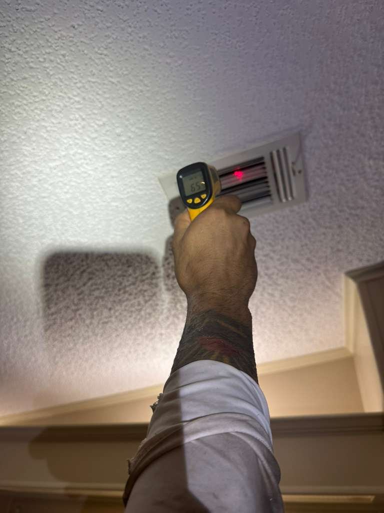 Technician measuring temperature at ceiling vent in Plant City, FL 33565.