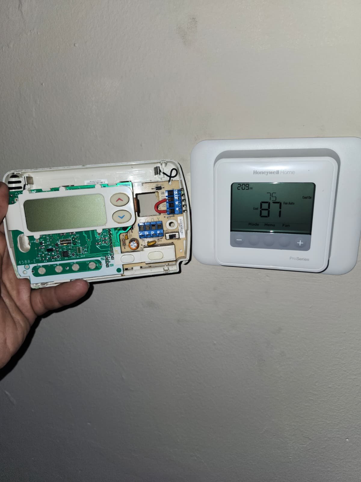 Old thermostat being replaced with new in Tampa, FL 33607.
