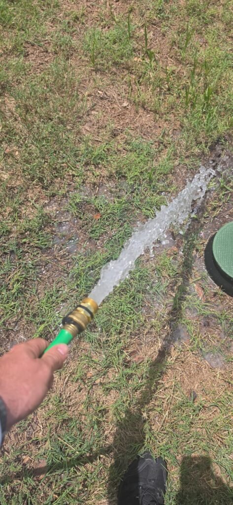 Water flushing from hose onto grass in Wimauma, FL 33598