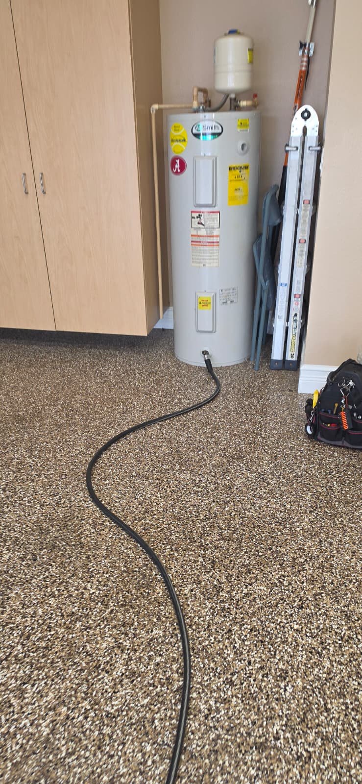 Water heater with hose connected in garage, Lutz, FL 33559. Detail from Visit #5. Plumbing #2.