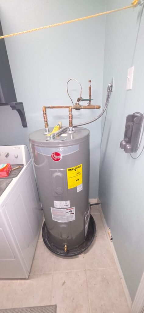 A new electric tank water heater on its drain pan in Wesley Chapel, FL 33545.