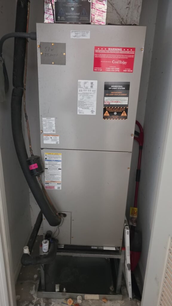 An indoor air handler in a closet during a full system tune-up in Tampa, FL 33611.