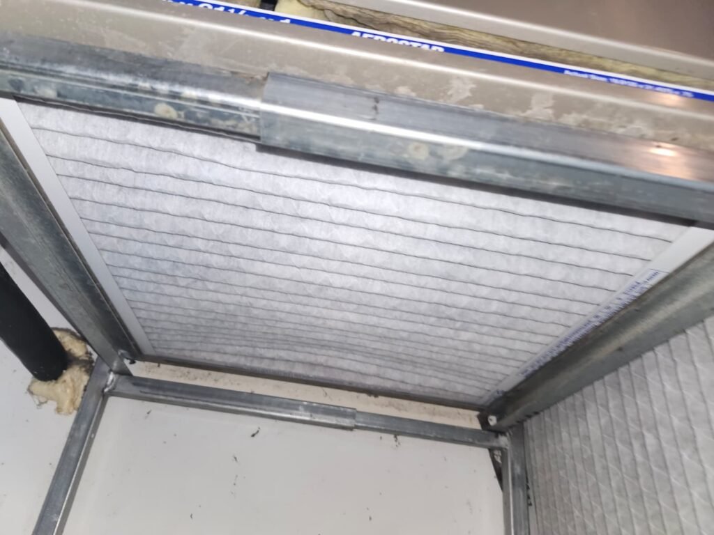 A new air filter seated in the filter rack of an air handler in Tampa, FL 33611.