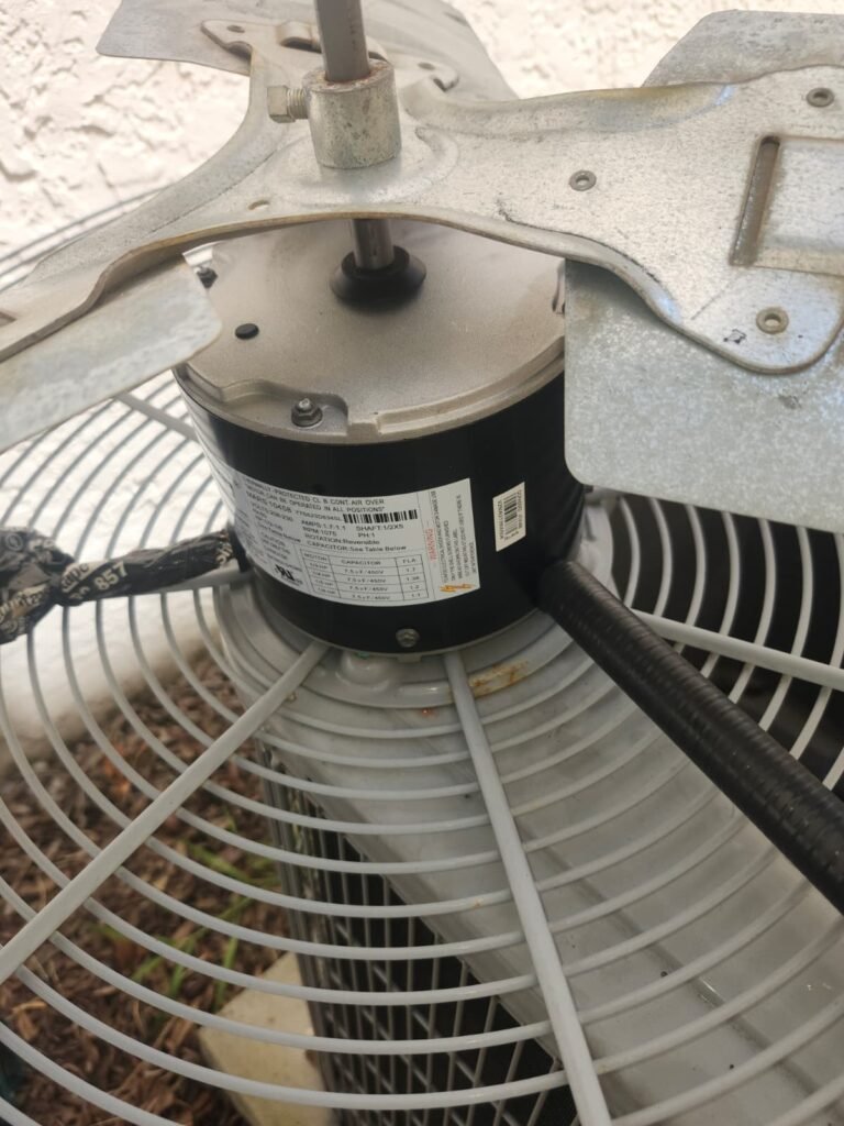 A new condenser fan motor installed on an outdoor AC unit in Tampa, FL 33617.