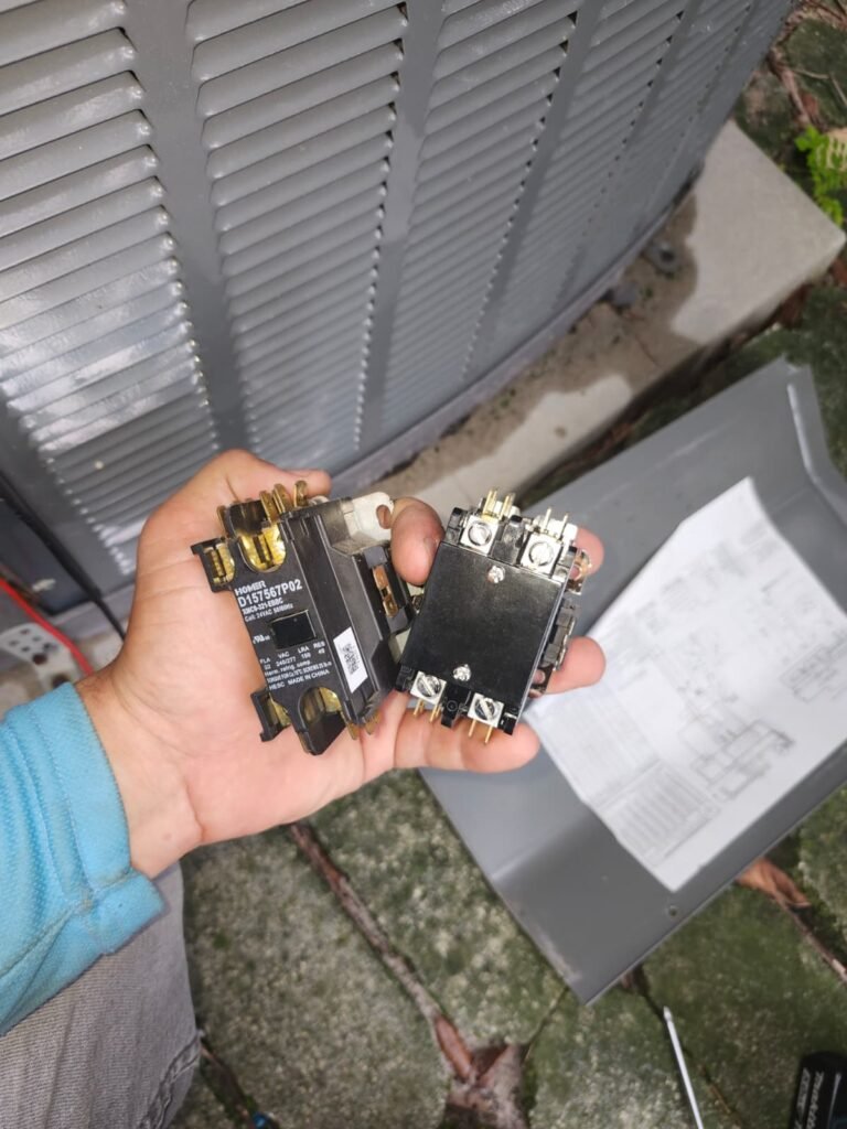 An old and a new AC contactor during a contactor replacement in Trinity, FL 34655.