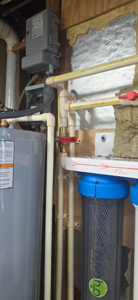 A water heater with a new shut-off valve and filter housing in Tampa, FL 33635.