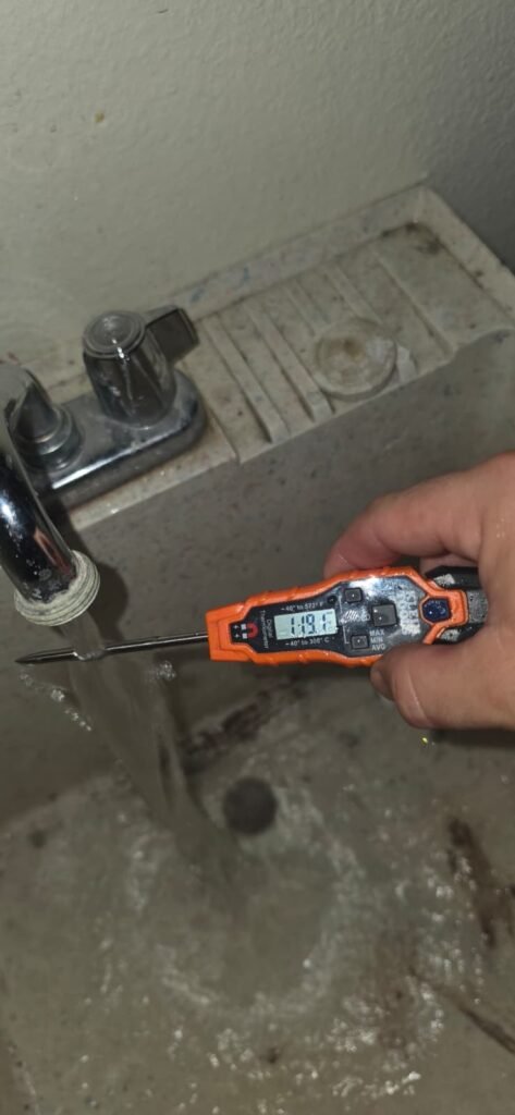 Checking hot water temperature at a faucet on a plumbing visit in Seminole, FL 33776.