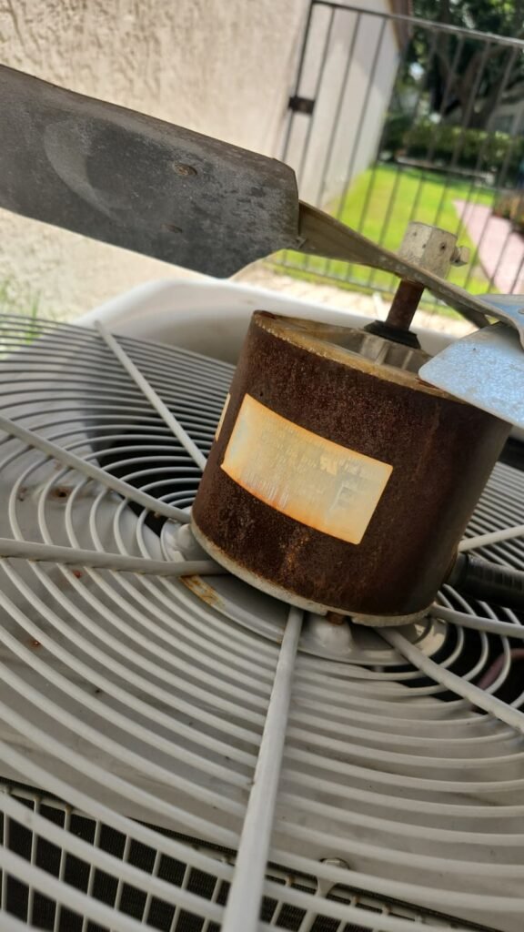 A rusted condenser fan motor on top of an outdoor AC unit in Tampa, FL 33617.
