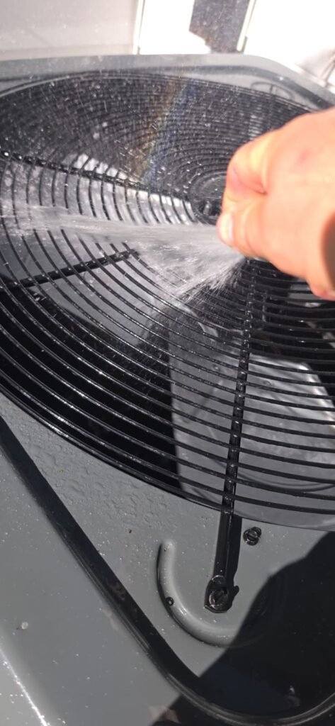 Spraying water on HVAC fan during maintenance in Tampa, FL 33603