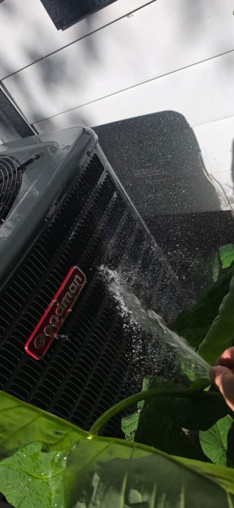 Spraying water on HVAC unit during maintenance in Tampa, FL 33603