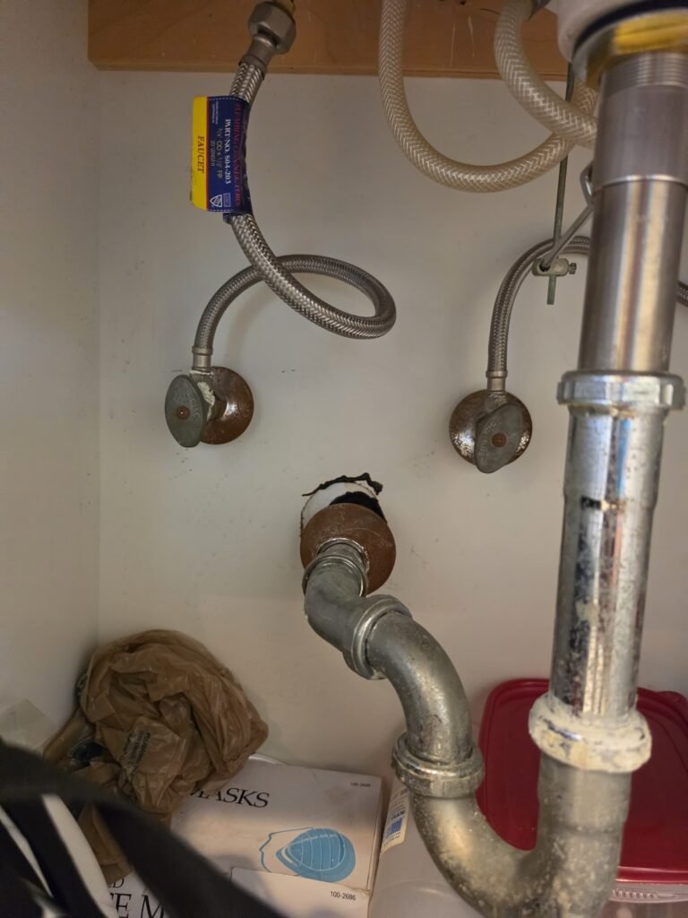 Under-sink plumbing with old valves before replacement in Tampa, FL 33629