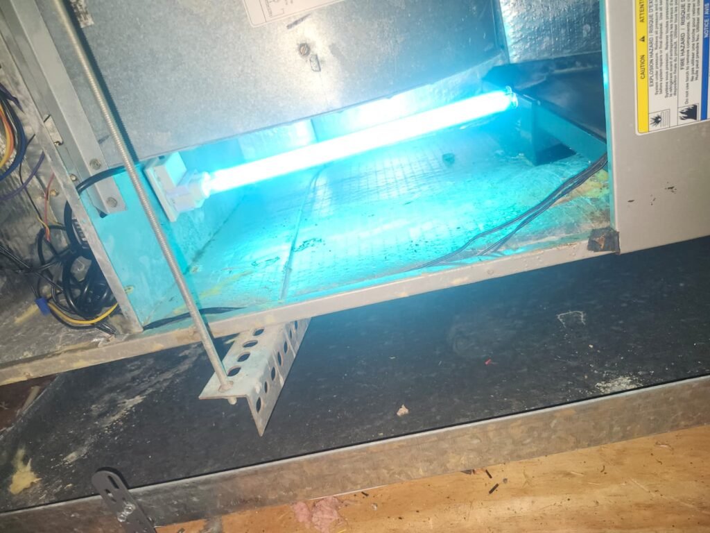 A UV-C lamp glowing inside an air handler in Tampa, FL 33635.