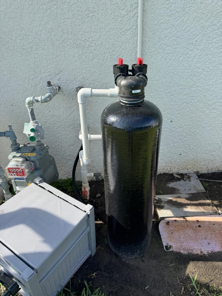 A whole-home water filter tank installed on an outside wall in Land O’ Lakes, FL 34637.