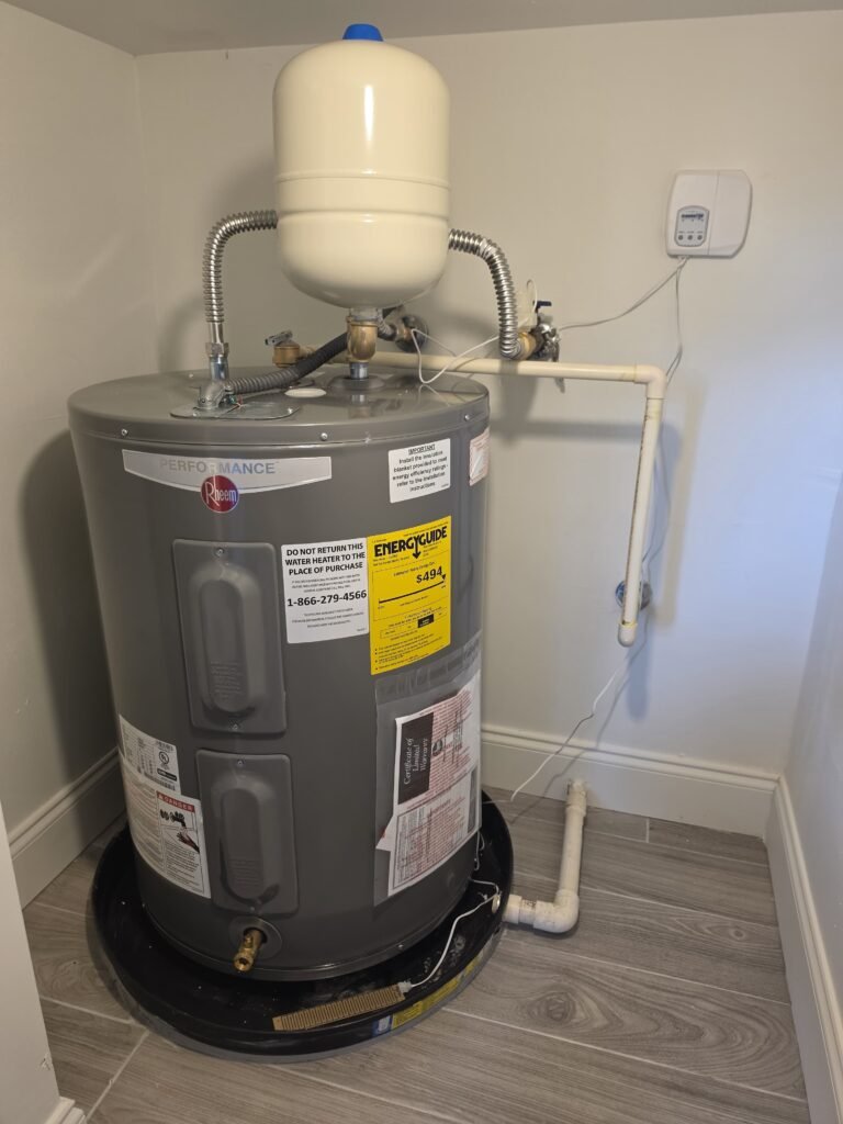 A water heater with a thermal expansion tank mounted above it in Tampa, FL 33616.