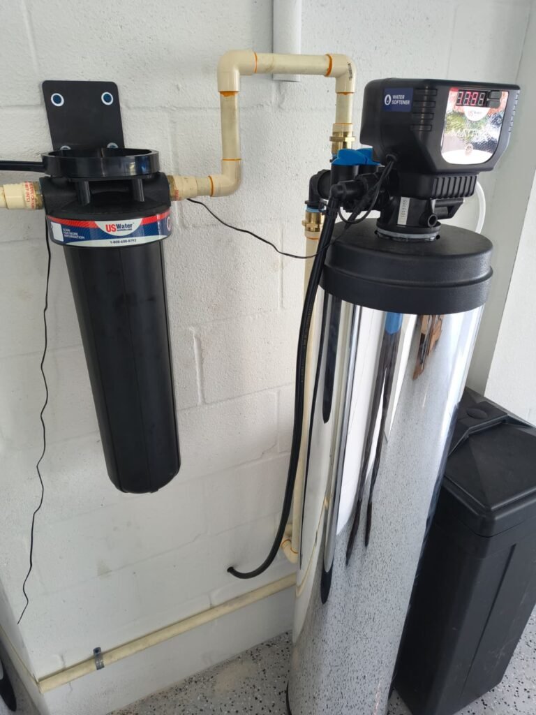 A softener resin tank and control head next to a sediment filter in San Antonio, FL 33576.
