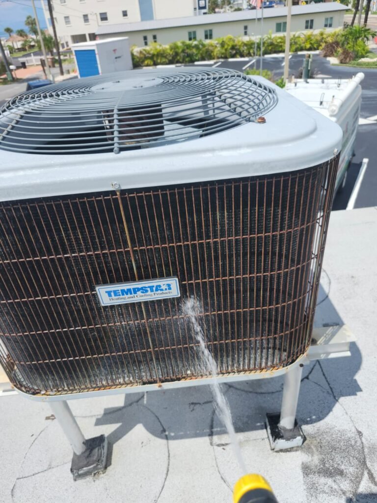 Rinsing the condenser coil on a rooftop AC in Madeira Beach, FL 33708.