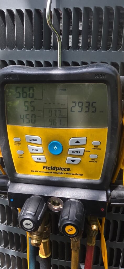 A digital manifold gauge reading system pressures during an AC tune-up in Tampa, FL 33624.