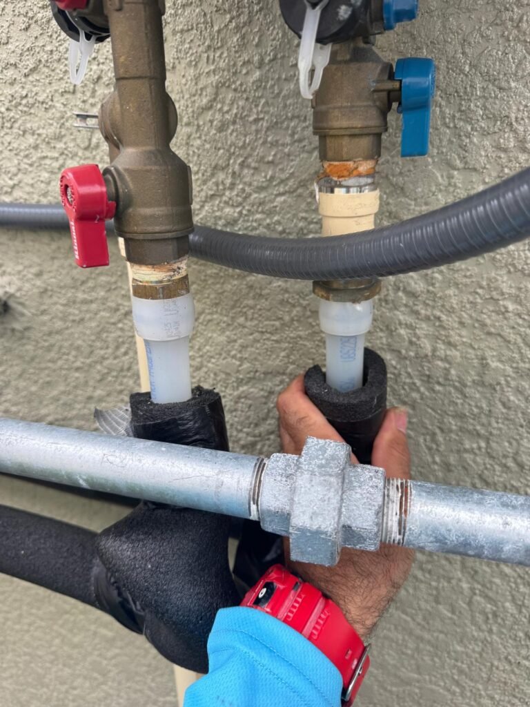 Hand adjusting pipe insulation on tankless water heater in Land O' Lakes, FL 34637.