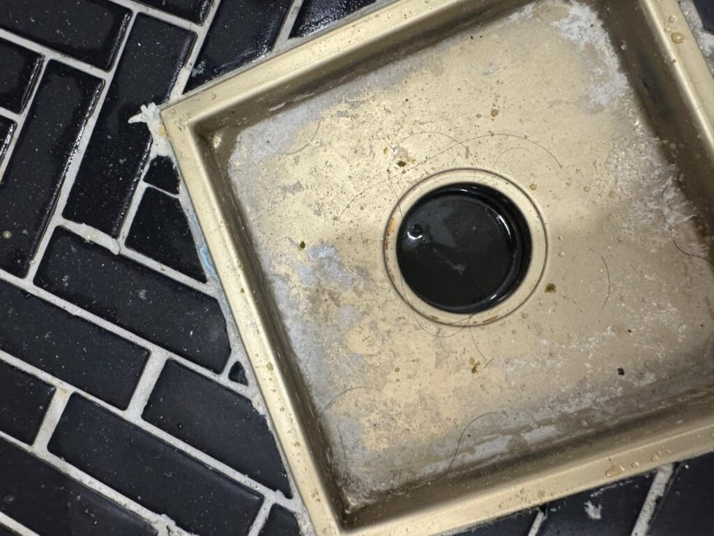 Hair and soap residue around a shower drain in Tampa, FL 33615.