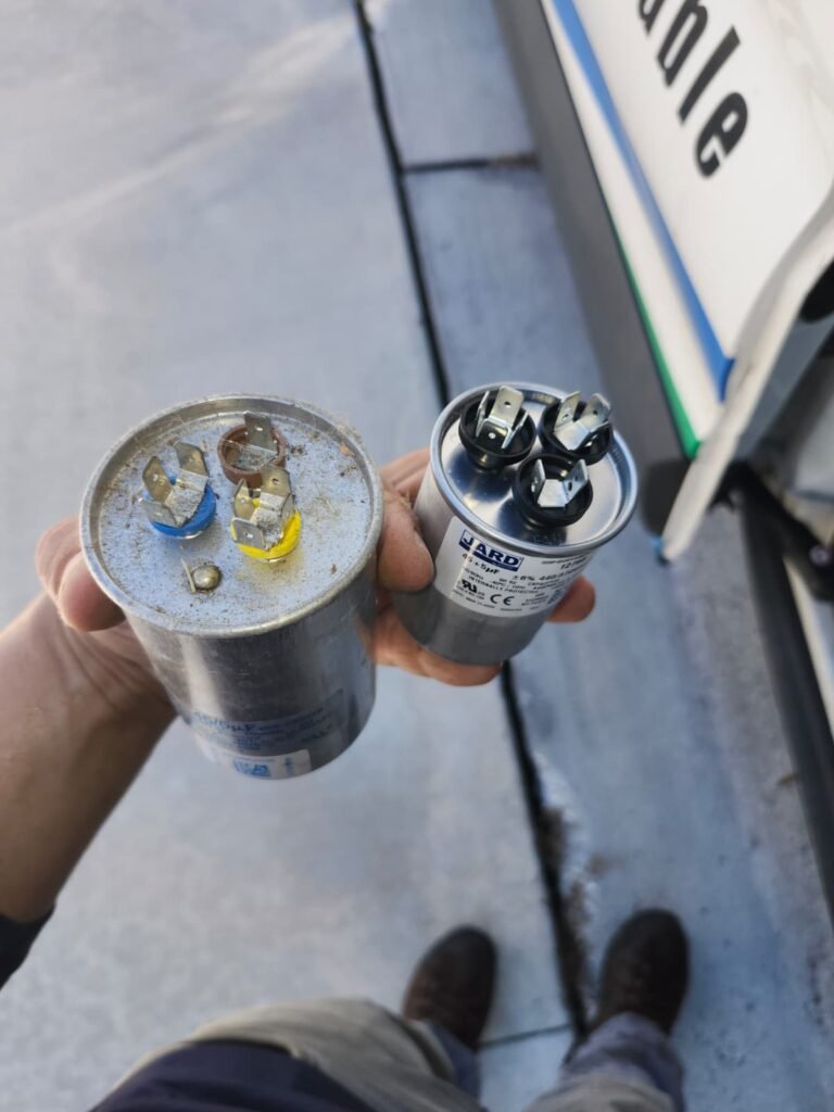 An old capacitor next to its new replacement in Riverview, FL 33578.