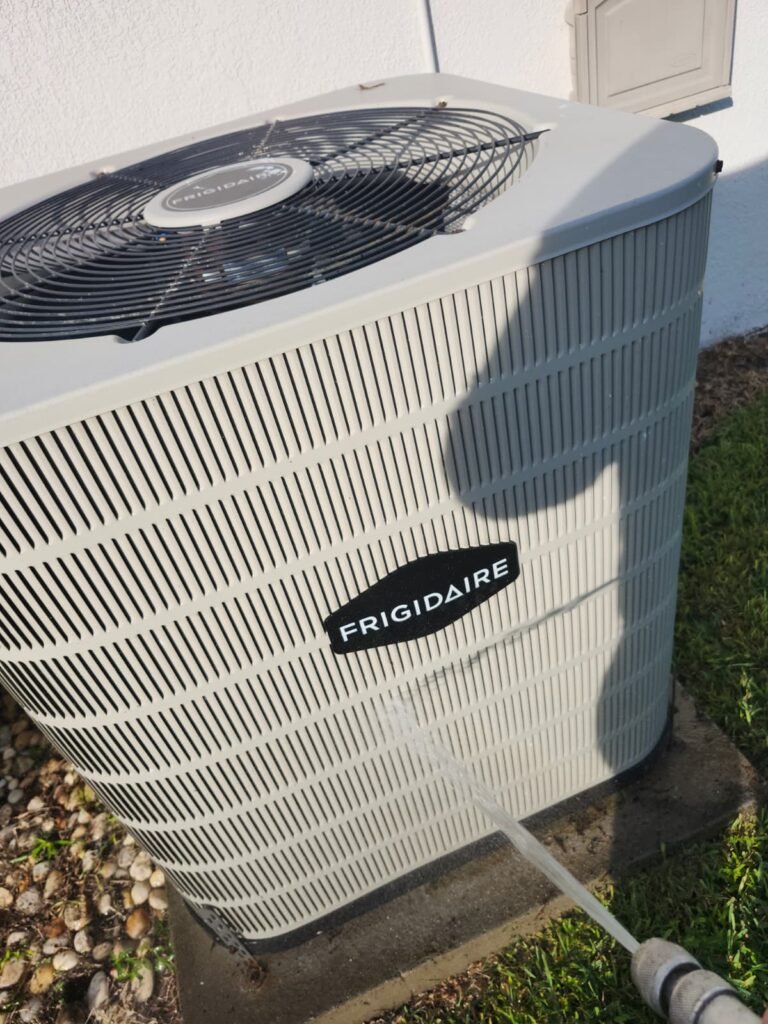 Cleaning HVAC Unit Side in Valrico, FL 33594 Cleaning side of HVAC unit during maintenance in Valrico, FL 33594