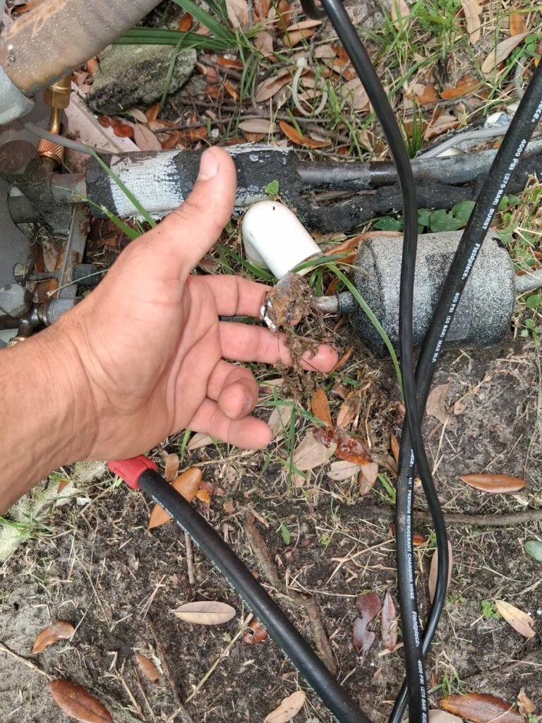 Technician holding component near AC unit in Tampa, FL 33605