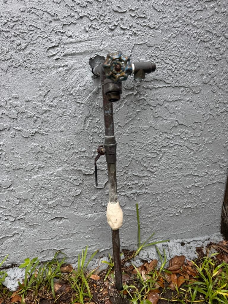 A repaired copper riser at an outdoor faucet on an exterior wall in Tampa, FL 33624.