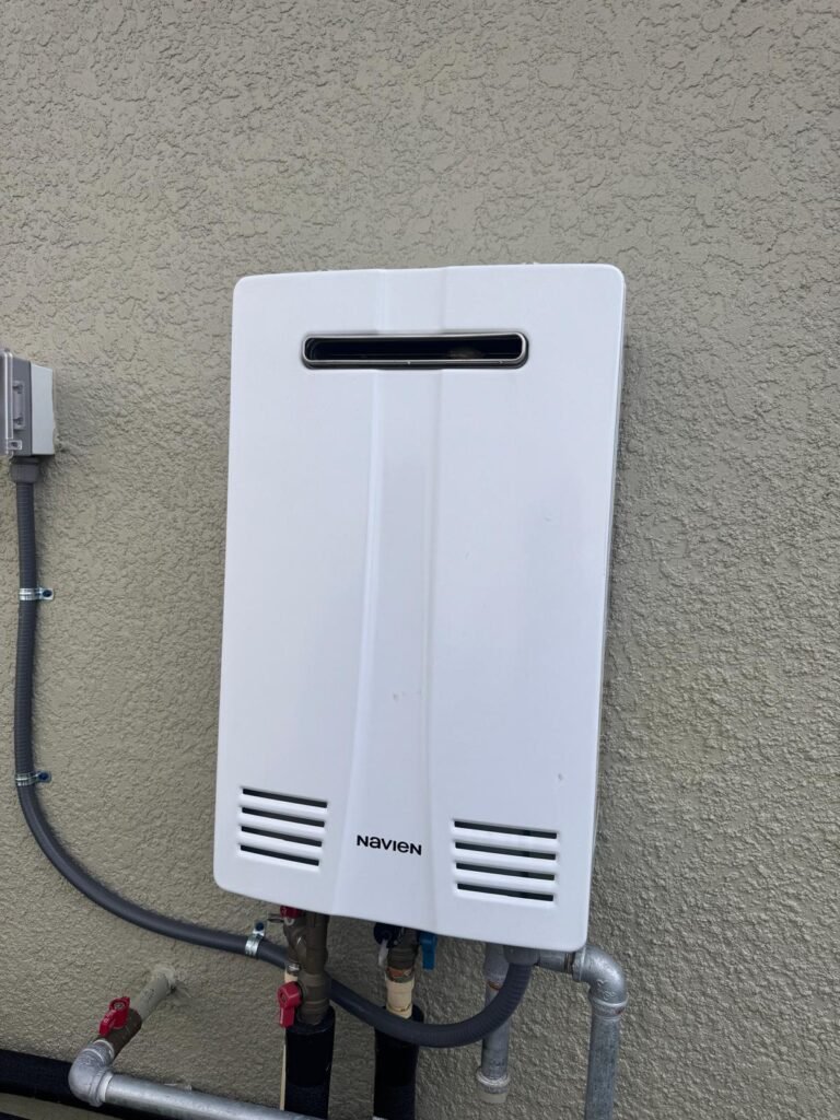 A tankless water heater installed on an exterior wall in Land O’ Lakes, FL 34637.