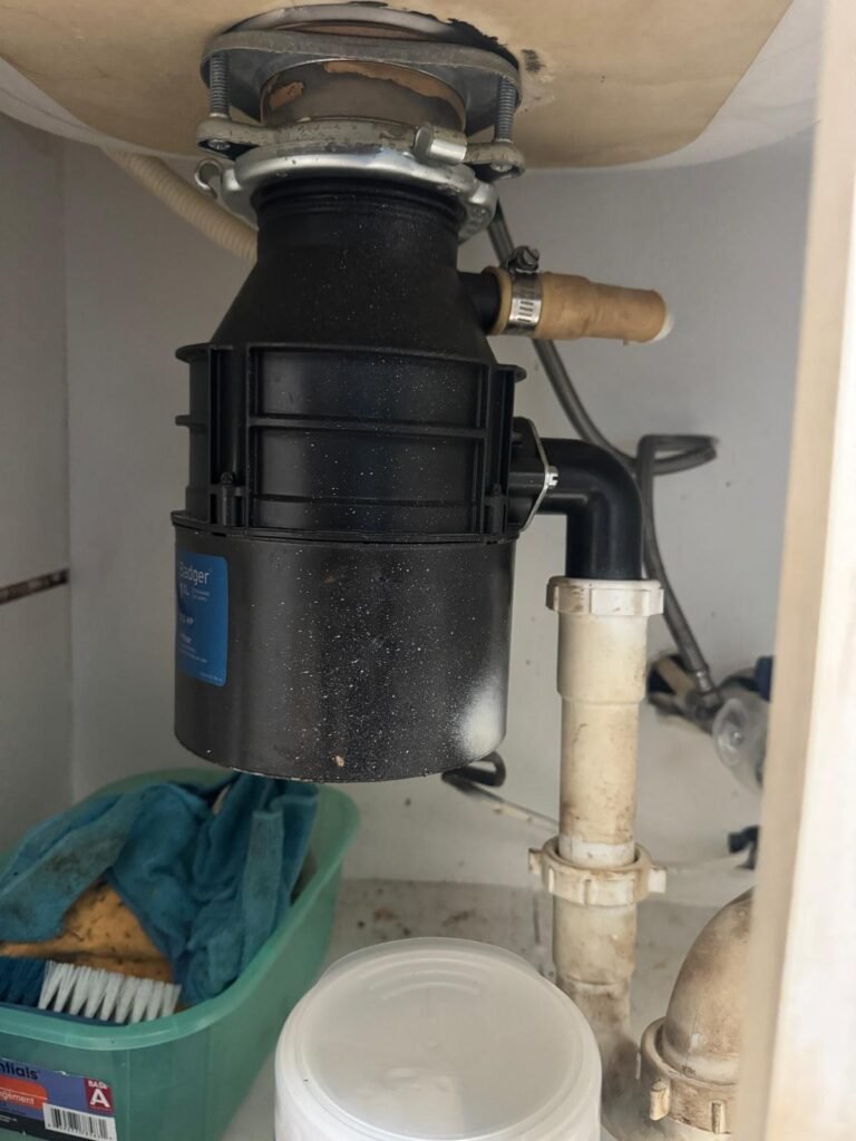 A garbage disposal mounted under a kitchen sink in Tampa, FL 33617.