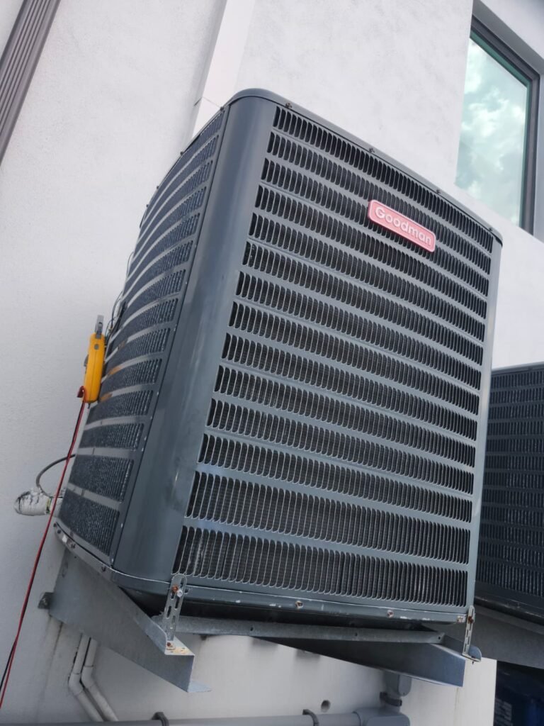 A Goodman condenser installed on a wall bracket in Saint Petersburg, FL 33703.