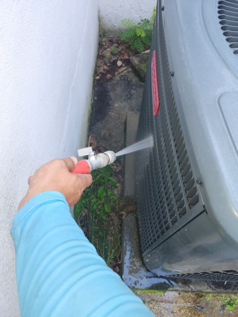 Rinsing an outdoor AC unit’s coil during a maintenance visit in Tampa, FL 33603.