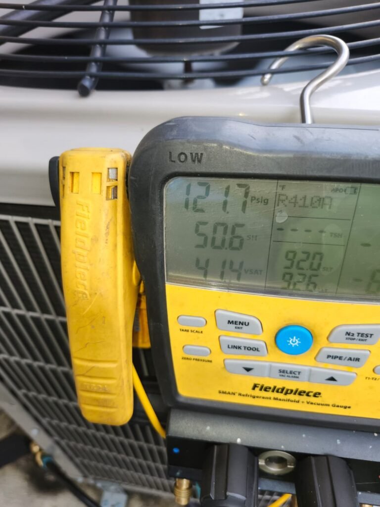 A digital manifold gauge reading pressures on an outdoor unit in Riverview, FL 33578.