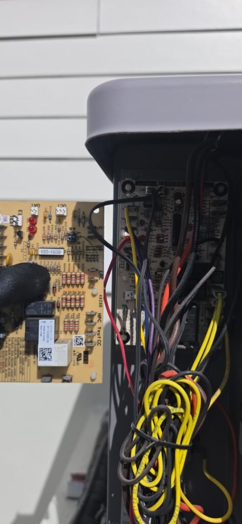 Technician holding defrost board near HVAC wiring in Apollo Beach, FL 33572