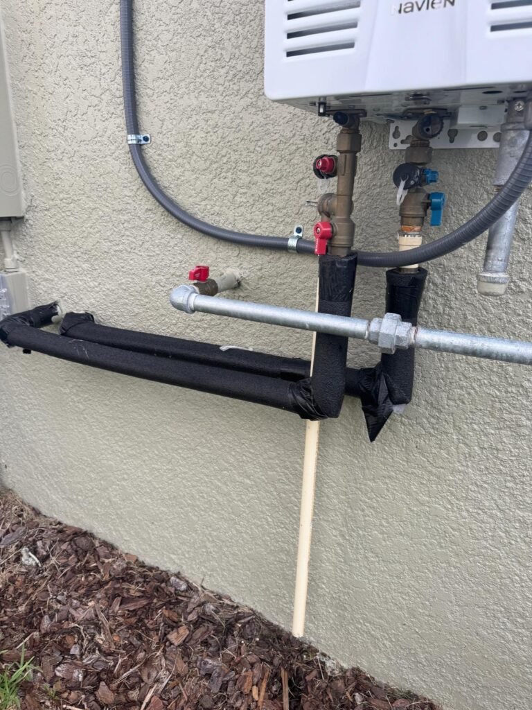Installed tankless water heater with insulated pipes in Land O' Lakes, FL 34637.