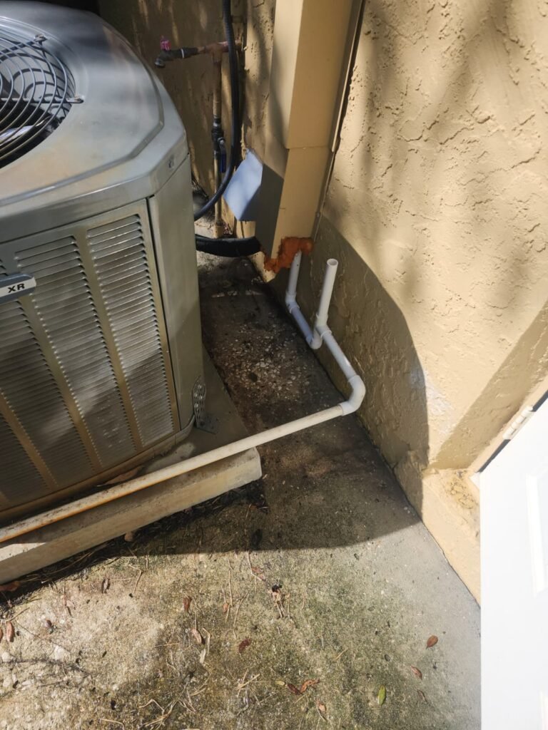 HVAC unit with PVC drain line against wall in Tarpon Springs, FL 34689