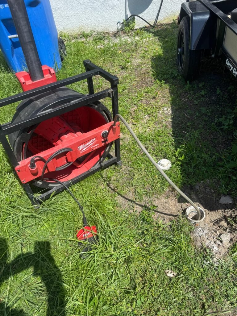 A drain cable machine set up at an outdoor cleanout in Tampa, FL 33615.